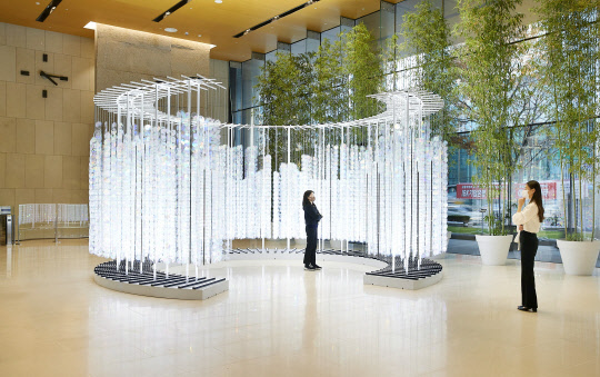 23일 서울 중구 을지로 기업은행 본점에서 윤종원(오른쪽) IBK기업은행장과 이지연 작가가 '얼룩무지개 숲 3' 작품에 관해 대화를 나누고 있다. 기업은행 제공